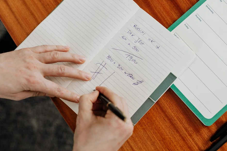 Persona che scrive su un taccuino durante una riunione di strategia